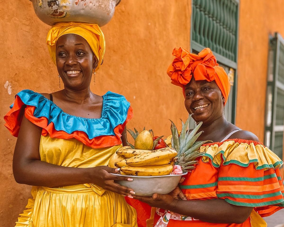Mujeres colombianas sonrientes con frutas frescas
