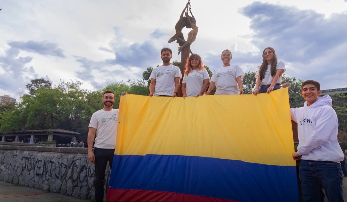 Estudiantes preparando una presentación de investigación para un viaje internacional.