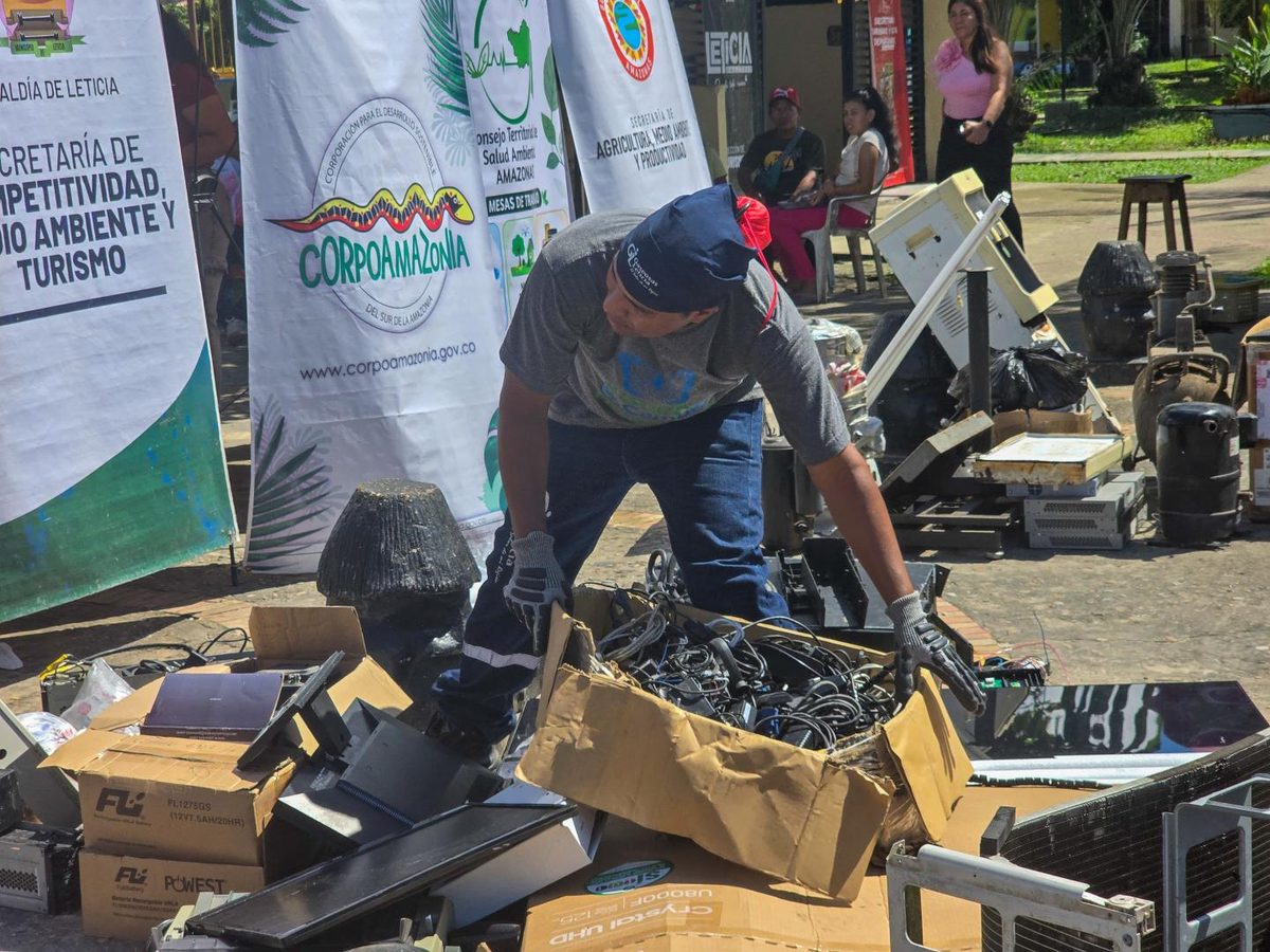 Montones de residuos electrónicos y electrodomésticos clasificados para reciclaje en un centro ambiental.