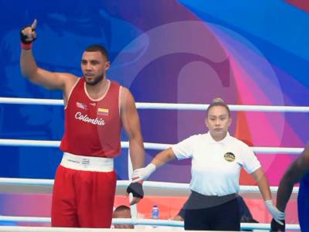 Un boxeador levantando los brazos tras una victoria en el ring.