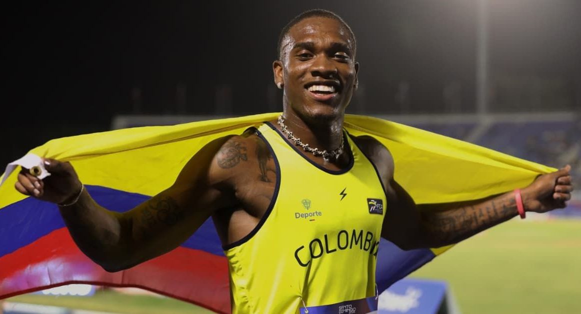Pista de atletismo en un estadio olímpico al atardecer.